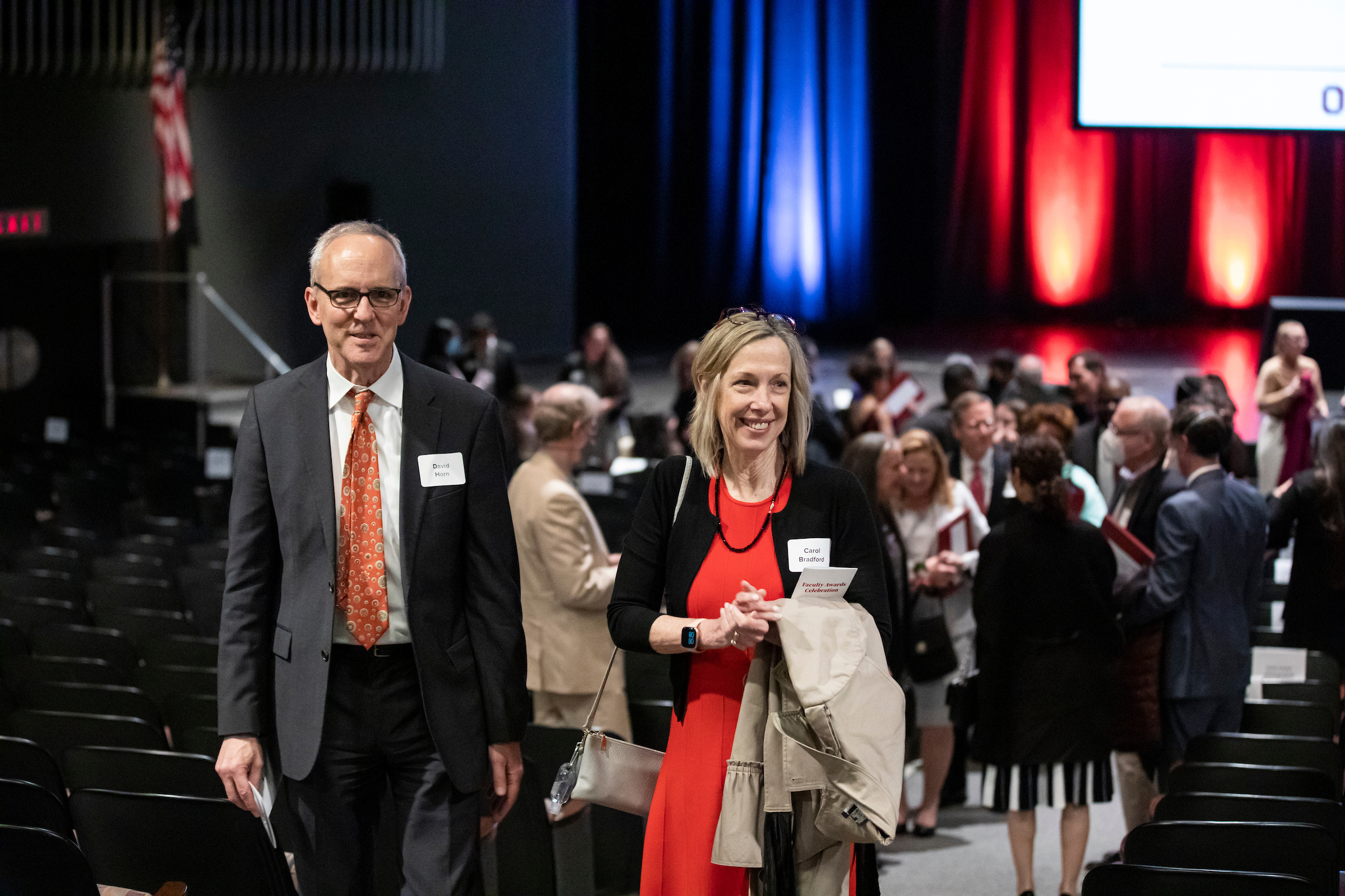 Two faculty members at the Faculty Awards Ceremony walk up the middle aisle of the Mershon Auditorium.