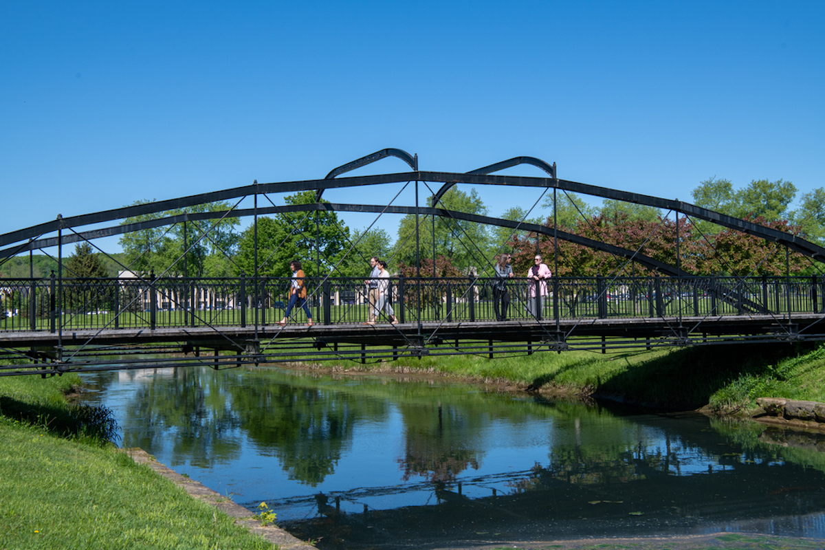 Picture of people walking across a bridge on a regional campus.
