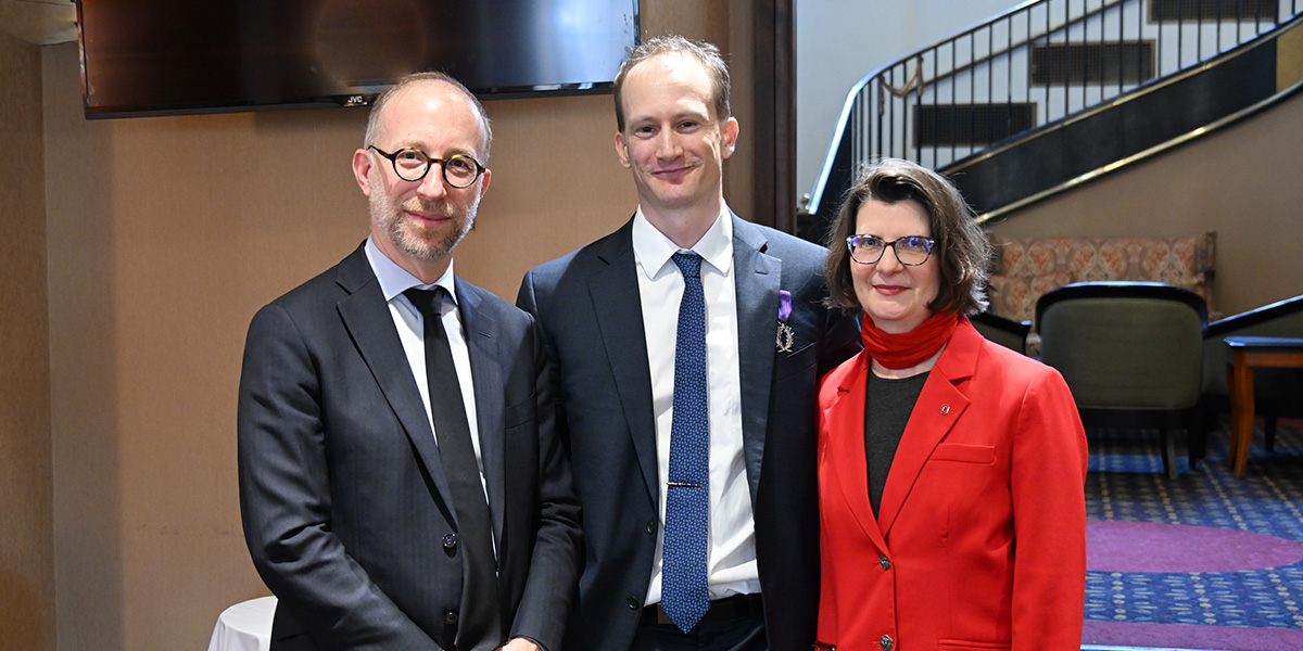 Benjamin Hoffman and two others stand inside the faculty club.