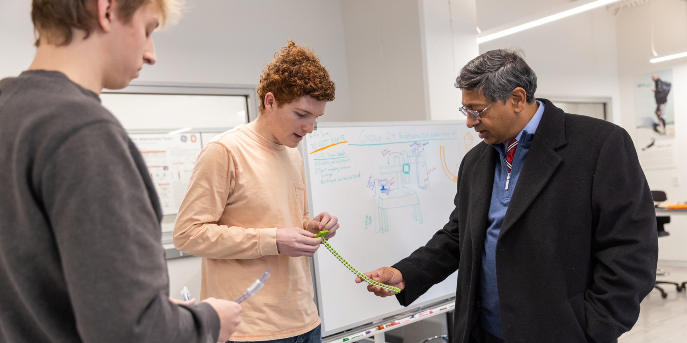 Two biomedical engineering students show their work to Provost Bellamkonda