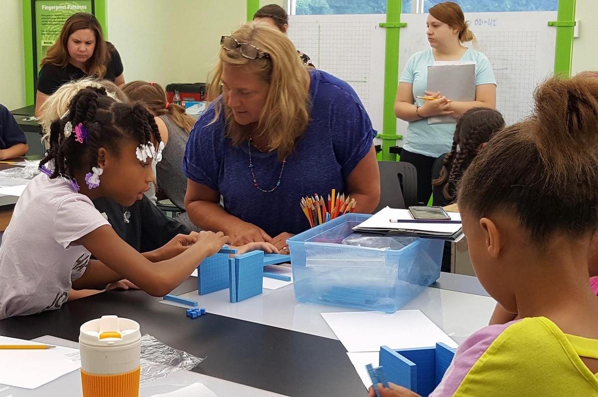 Terri Bucci speaks with young students in the classroom.