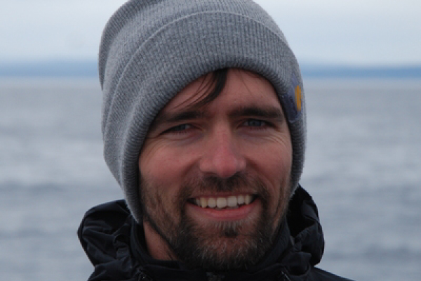 Picture of Bart Elmore in front of a large body of water.