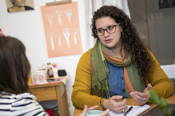 Candid photo of Dr. Mary Rodriguez seated and speaking to another person across a table.