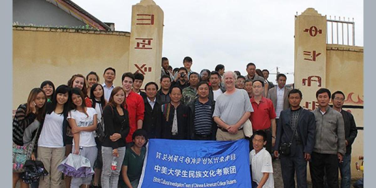 Group of students and faculty with a banner