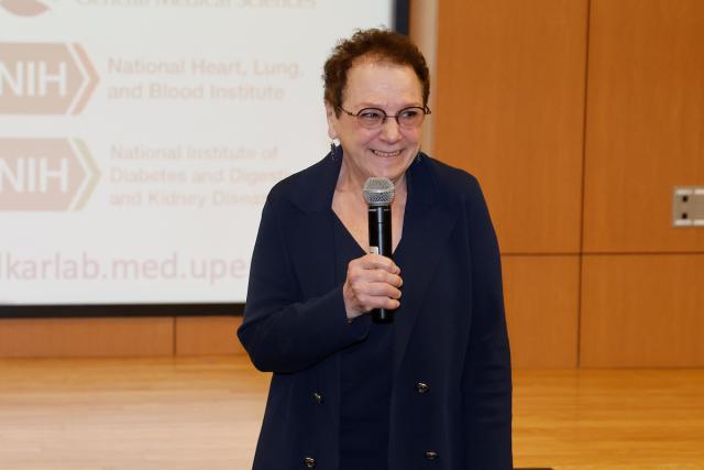 Anita Hopper standing in a classroom with a microphone.