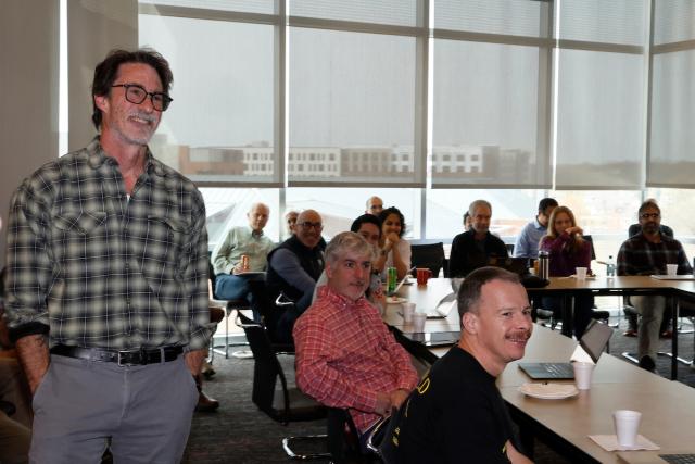Mike Lisa stands during a faculty meeting.