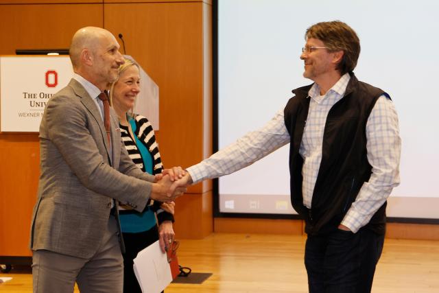 Phillip Popovich is congratulated by academic leaders.