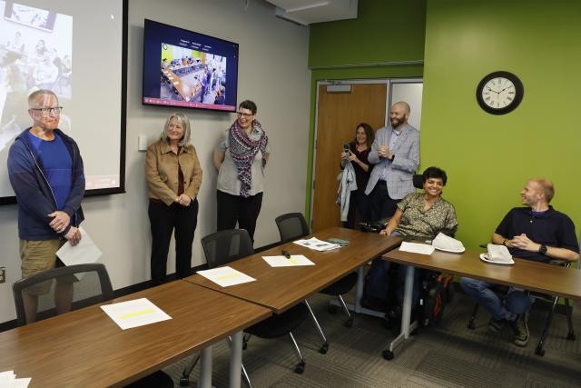 Brent Sohngen being congratulated by leadership in a classroom