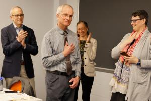 Peter Hahn holds his heart in thanks while three leaders applaud his award.
